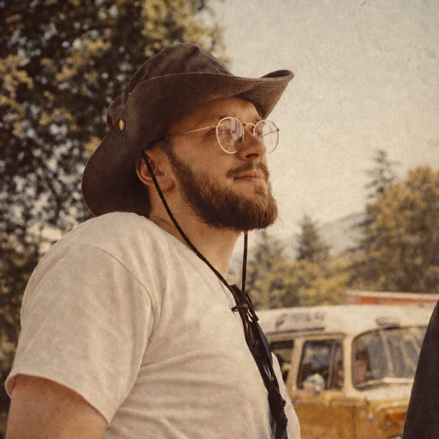 Mykola Khytra outdoors, wearing a hat and glasses